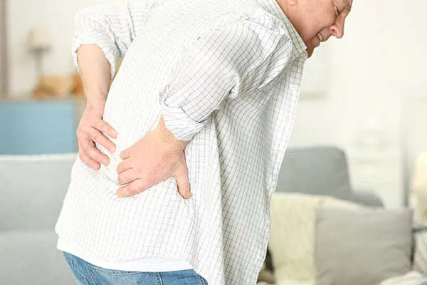 אדם מבוגר אוחז את הגב התחתון סובל מכאבי גב